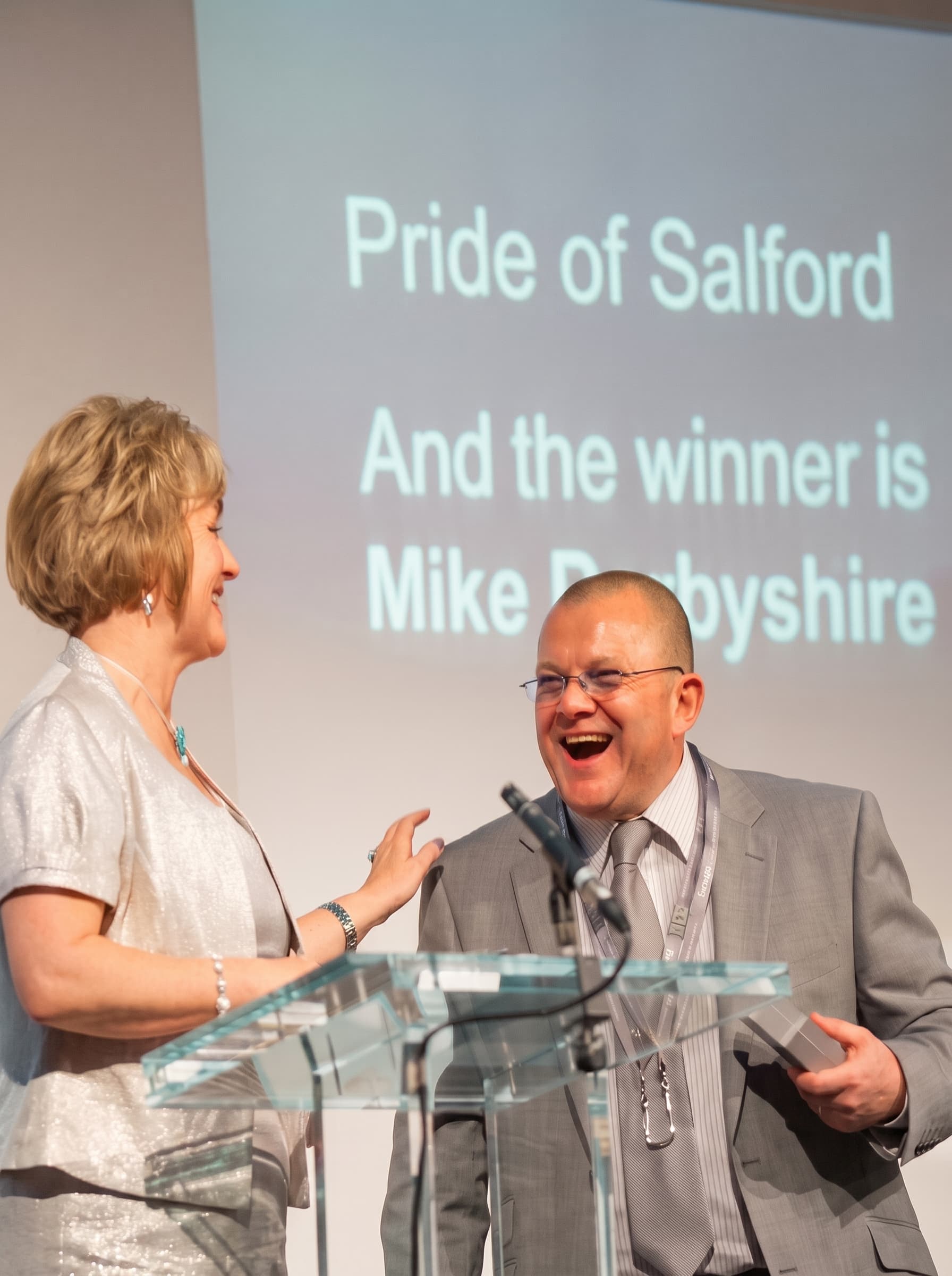 Mike Darbyshire receiving the Pride of Salford award on stage